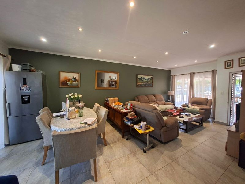 Spacious open-plan living and dining area featuring tiled flooring, recessed downlighting, and direct access to the outdoors through sliding glass doors.