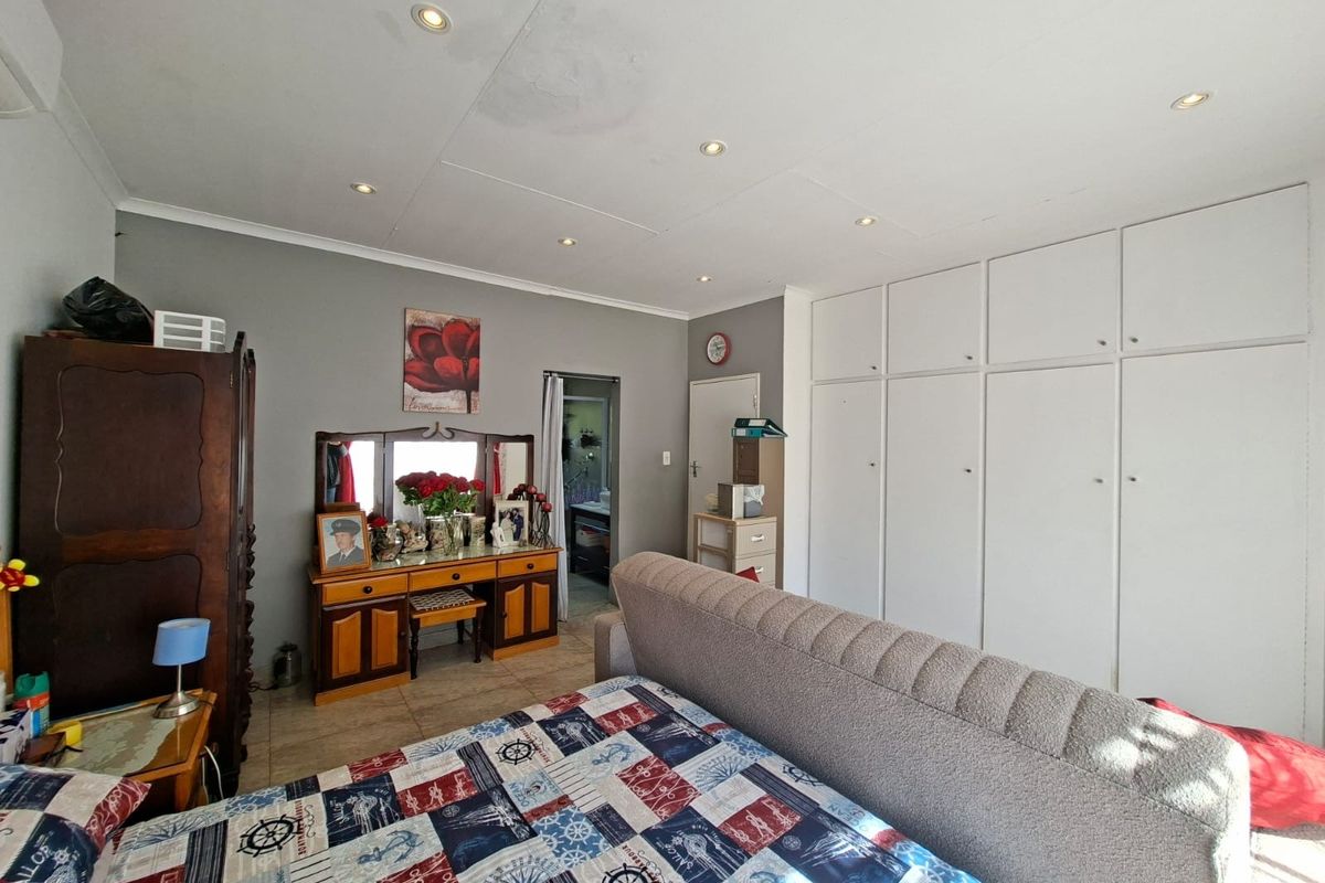 Bedroom featuring built-in cupboards, tiled flooring, and recessed downlights. Note visible ceiling water staining requiring attention.
