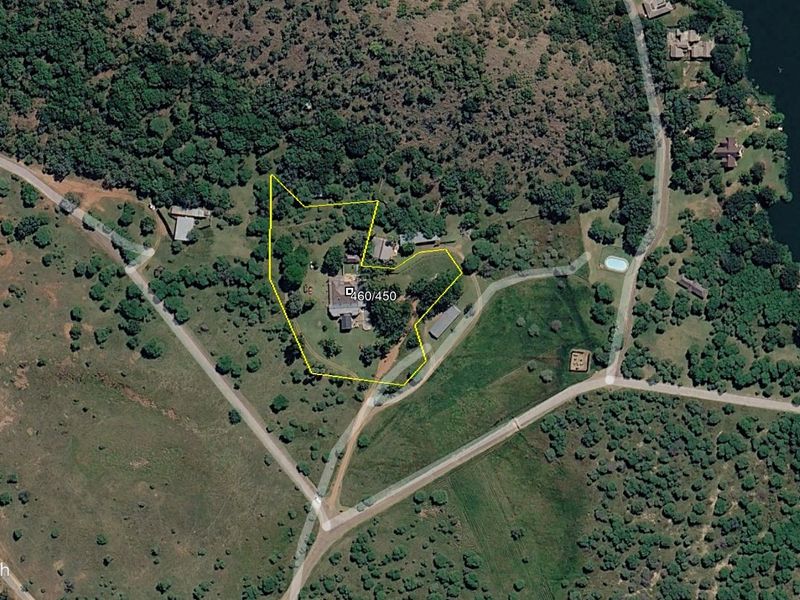 An aerial satellite view showing the property boundary and surrounding landscape, including access roads and nearby vegetation.