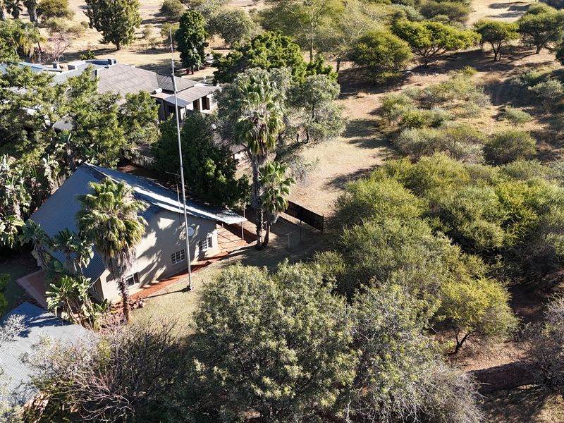 Aerial view of the lodge property showing the main building structure, surrounding grounds, and established trees within the estate.