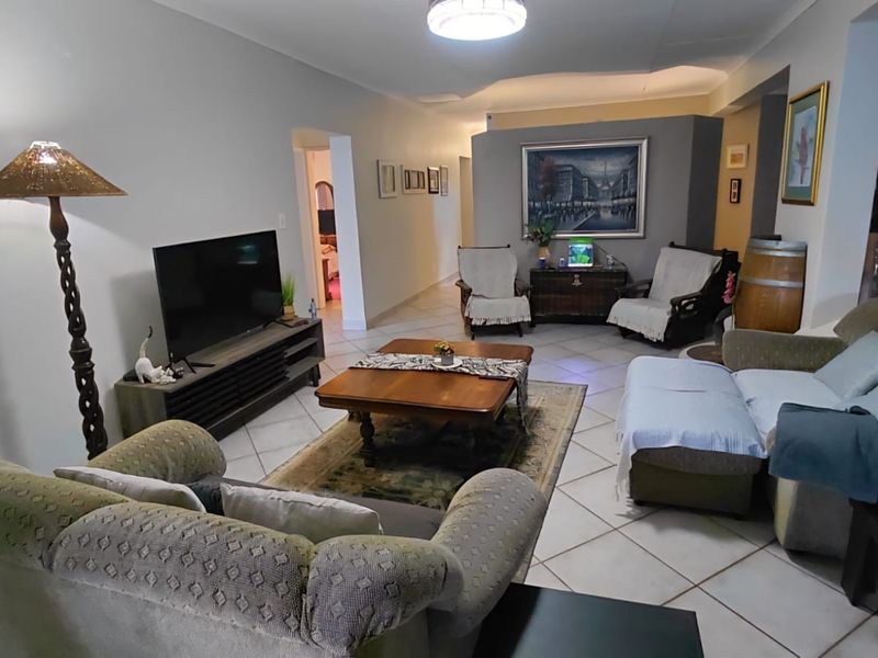 Spacious living room featuring tiled flooring and neutral wall tones, providing a comfortable and functional area for relaxation.