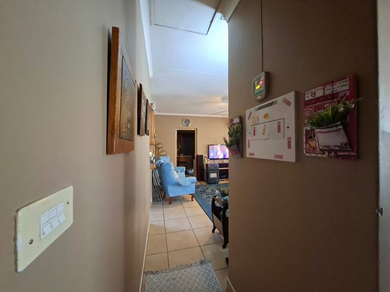 A view through a residential hallway with tiled flooring, leading into the main living area of the townhouse.