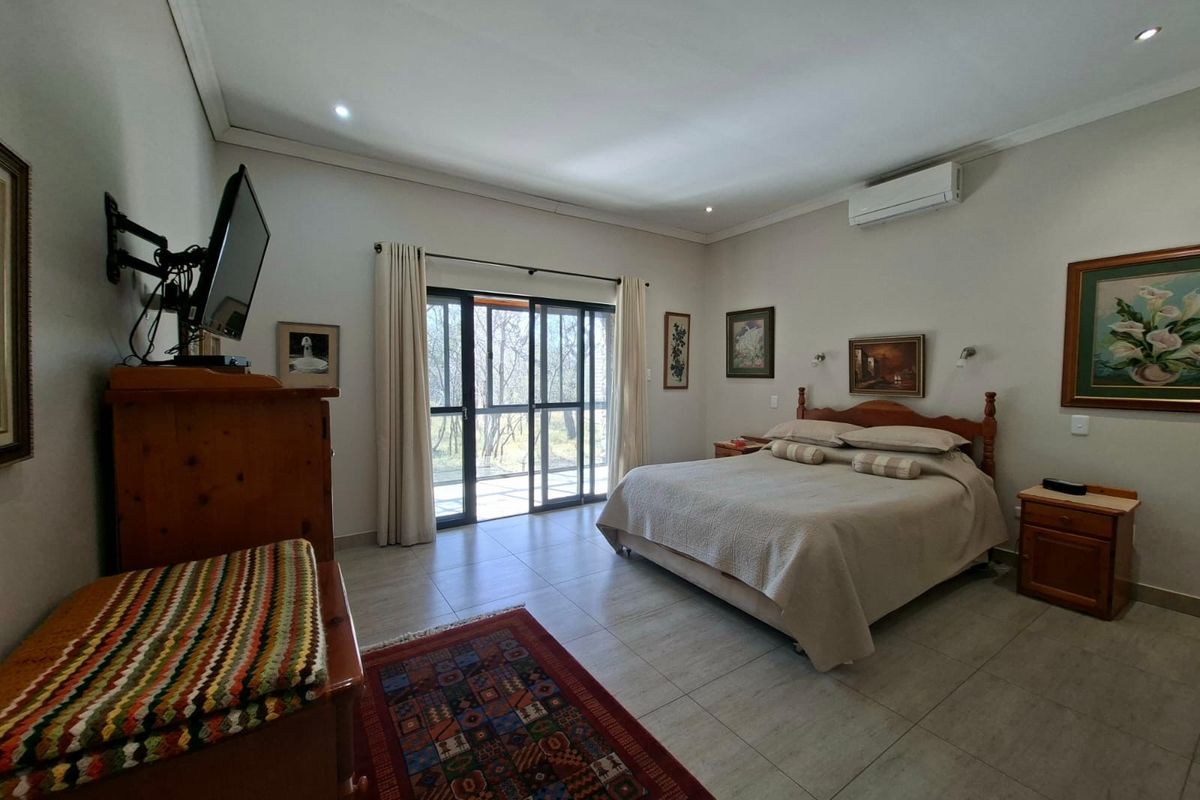 Spacious bedroom featuring tiled flooring, recessed lighting, a split-system air conditioner, and sliding glass doors providing access to the outdoors.