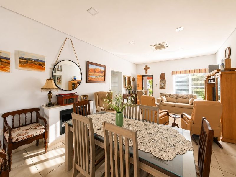 Spacious open-plan living and dining area featuring tiled flooring, recessed lighting, and a built-in fireplace, offering a comfortable and functional layout.