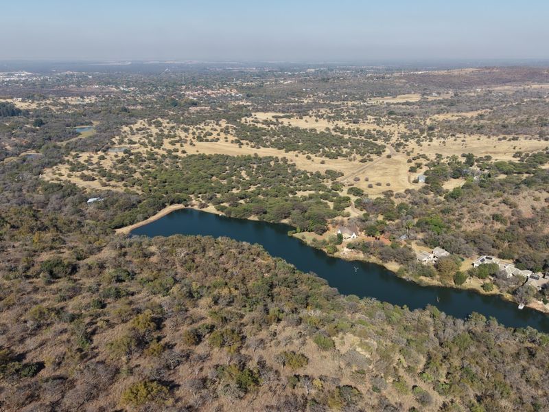 An aerial view of the residential vacant land featuring a natural dam and surrounding indigenous bushveld landscape.