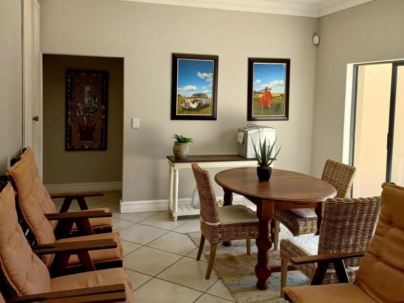 A well-maintained dining area featuring neutral wall tones, tiled flooring, crown molding, and recessed lighting, providing a bright and functional space for meals.