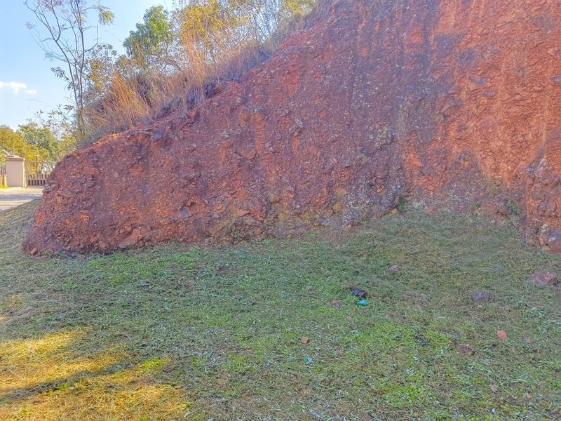 A view of a rocky embankment and natural terrain on the residential vacant land plot.