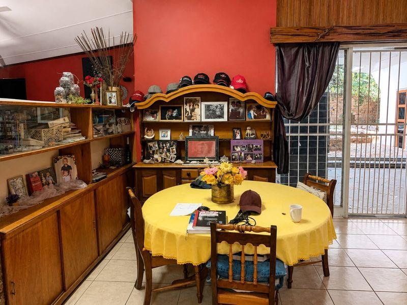 A dining room featuring built-in wooden cabinetry, tiled flooring, and direct access to an outdoor area through a sliding glass door.