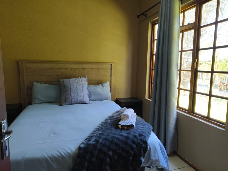A cozy bedroom featuring timber-framed windows that allow natural light, providing a comfortable and functional living space.