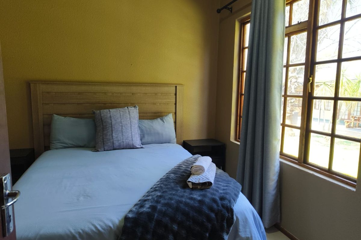 A cozy bedroom featuring timber-framed windows that allow natural light, providing a comfortable and functional living space.