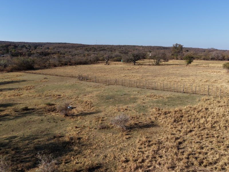 An aerial view of the expansive, open veld landscape featuring natural vegetation and existing wire boundary fencing.