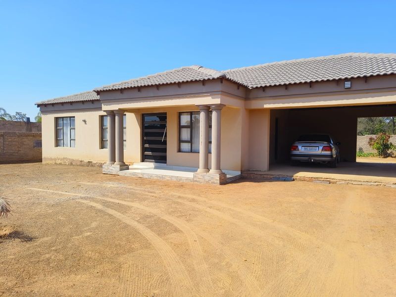 Front elevation of a single-story house featuring a covered entrance with decorative columns and an integrated double garage.