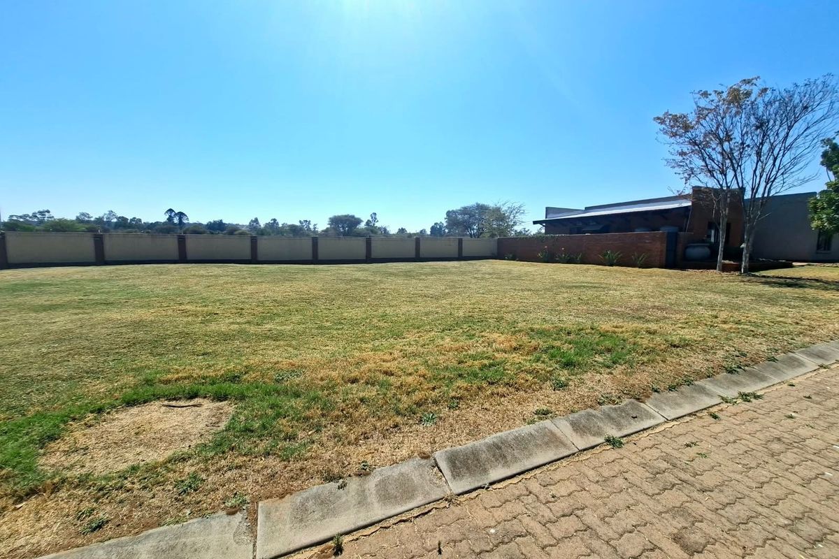 A spacious, level residential plot featuring a well-defined perimeter wall and established lawn, offering a clear canvas for future development.