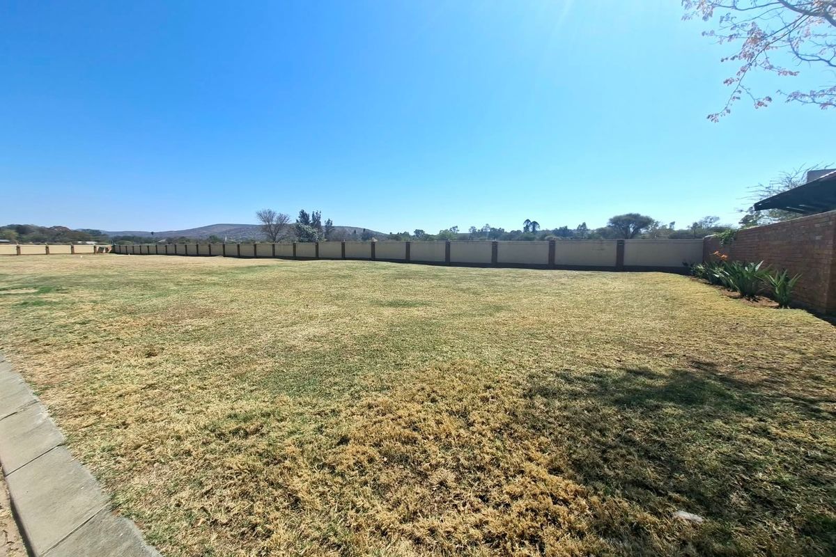 A spacious, level residential plot featuring a well-defined perimeter wall and established lawn area, offering potential for future development.