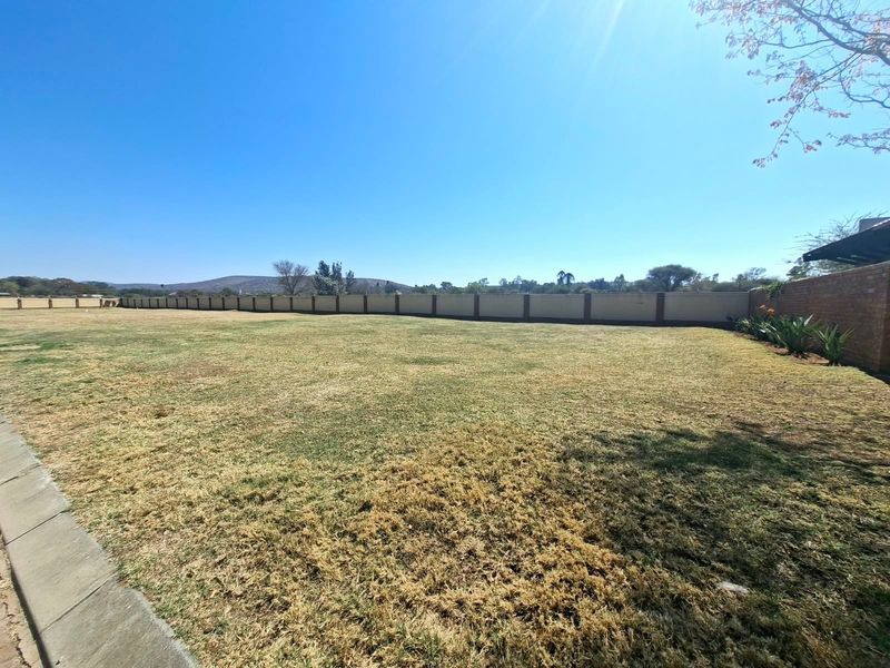 A spacious, level residential plot featuring a well-defined perimeter wall and established lawn area, offering potential for future development.