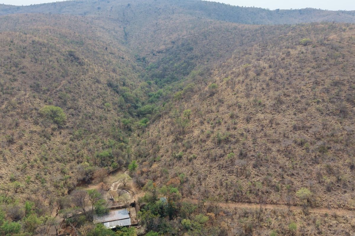 An aerial view of the expansive farm landscape, showcasing the natural terrain, valley, and surrounding vegetation.