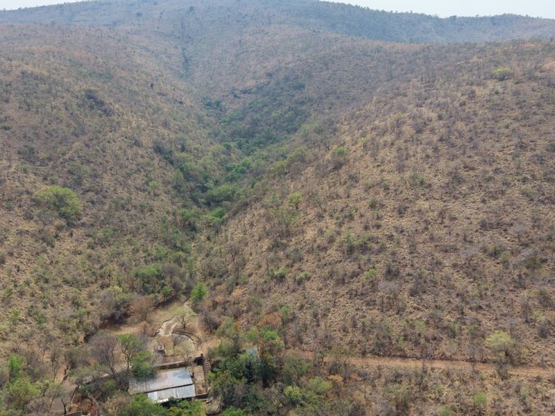An aerial view of the expansive farm landscape, showcasing the natural terrain, valley, and surrounding vegetation.