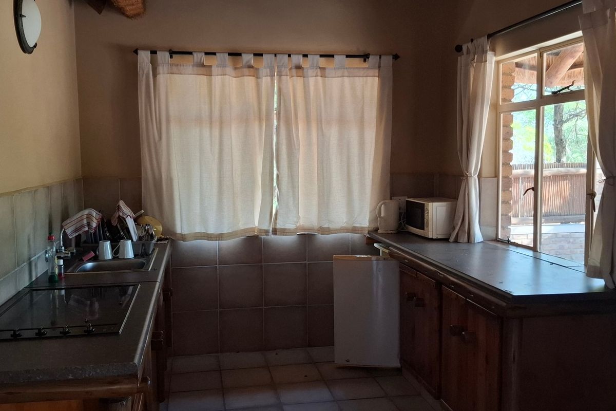 A functional kitchen area featuring built-in cabinetry, tiled backsplash, and a built-in hob, offering a practical layout for daily meal preparation.
