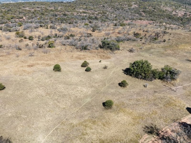 An aerial view of the expansive farm property, showcasing the natural landscape, indigenous vegetation, and open terrain.
