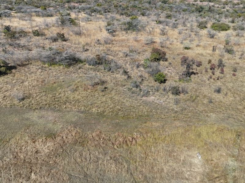 An aerial view of the expansive natural farm landscape featuring open grasslands and native vegetation.