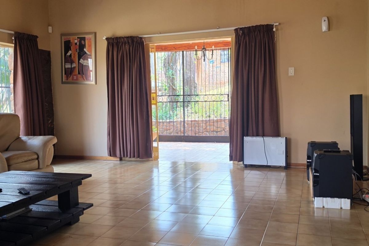 Spacious living room featuring tiled flooring and a sliding glass door providing direct access to the outdoor patio area.
