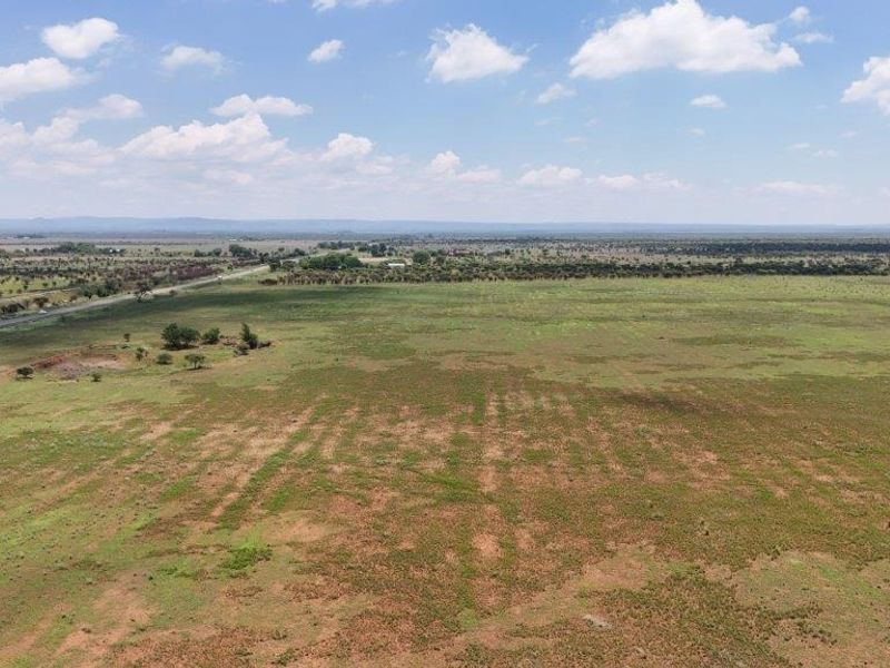 An expansive aerial view of the open farm land and surrounding rural landscape.