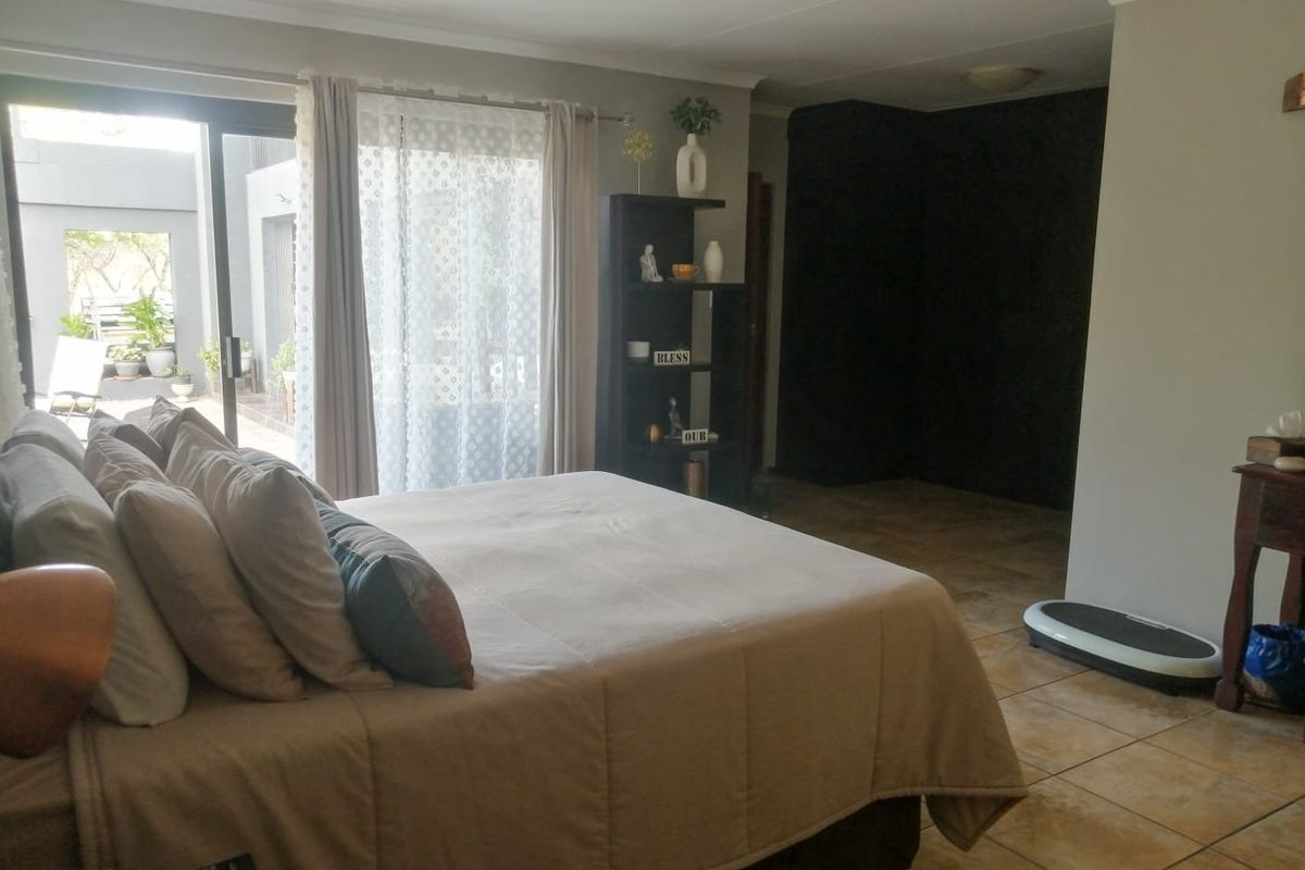 Spacious bedroom featuring tiled flooring and a sliding glass door providing access to an outdoor patio area.