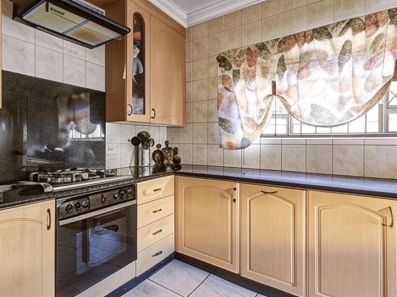 A functional kitchen featuring light wood cabinetry, dark granite countertops, a built-in oven with gas hob, and tiled finishes throughout.