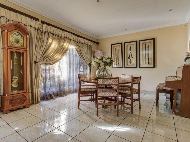 A well-lit dining room featuring polished tiled flooring and coved ceilings, providing a neutral and functional space for family meals.