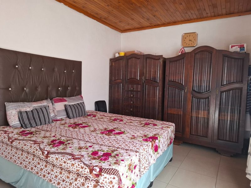 A bedroom featuring a timber-clad ceiling and tiled flooring, providing a functional space with traditional finishes.