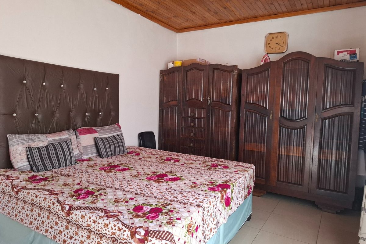 A bedroom featuring a timber-clad ceiling and tiled flooring, providing a functional space with traditional finishes.