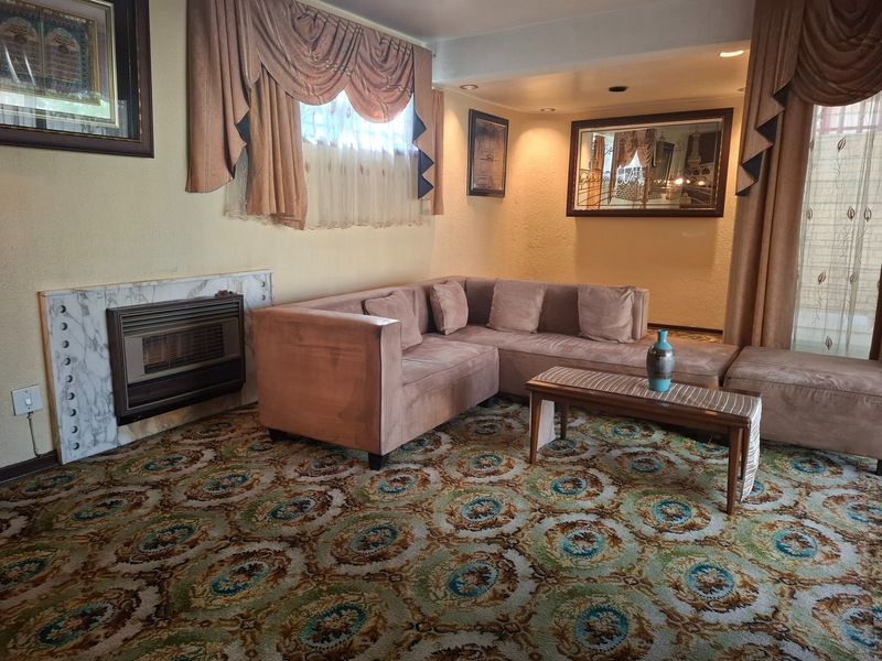 A living room featuring a gas fireplace with a marble surround, recessed lighting, and patterned wall-to-wall carpeting.