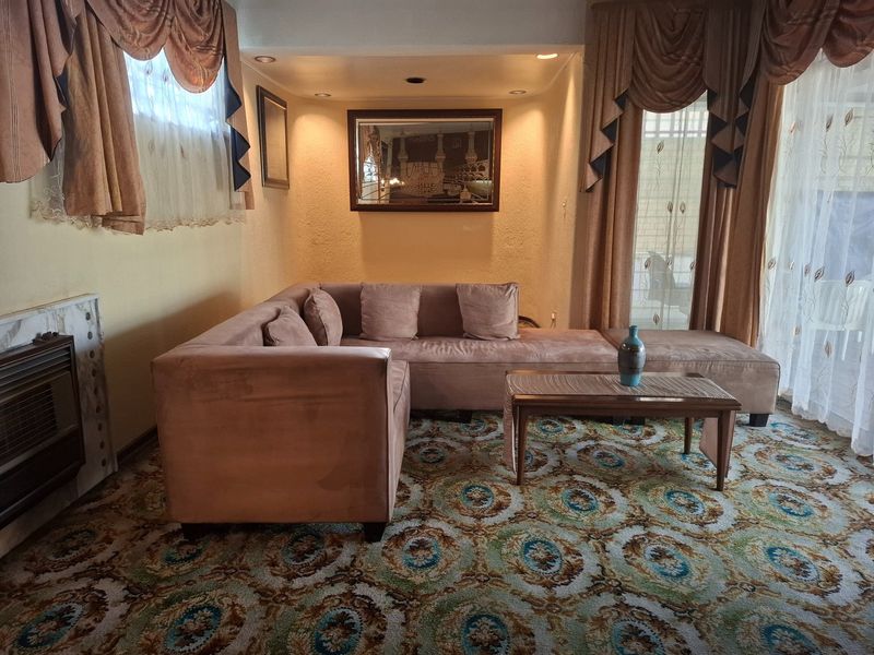 A living room featuring a gas fireplace with marble surround, recessed lighting, and access to the outdoors via a sliding glass door.