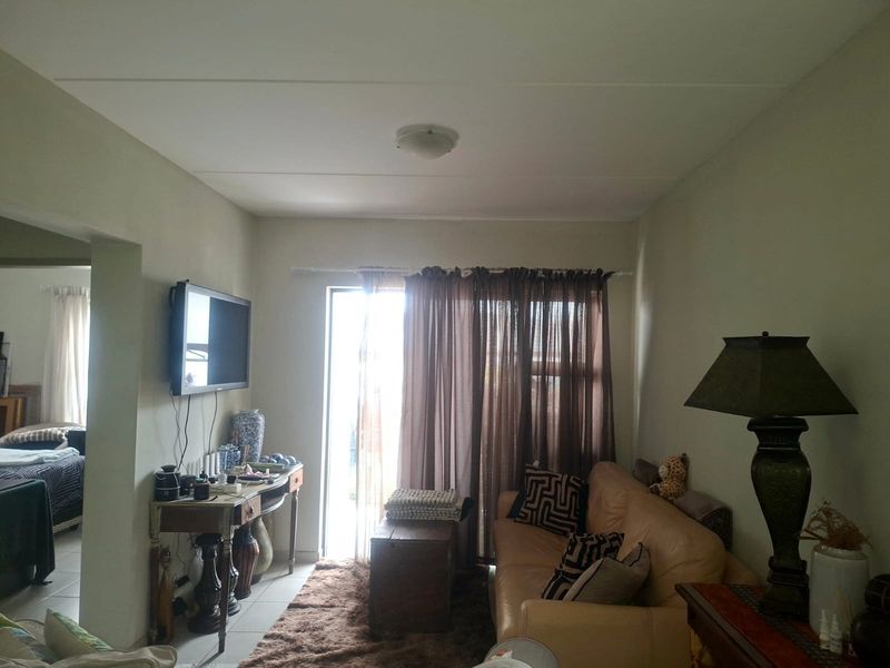A living room area featuring a sliding glass door providing natural light and access to the exterior.