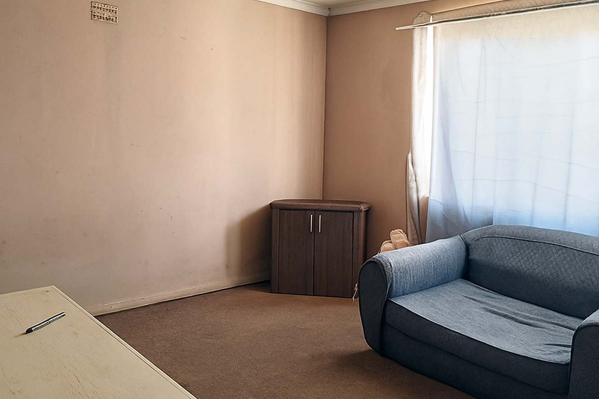 A living room space featuring neutral wall tones, carpet flooring, and coving, offering a blank canvas for potential interior updates.