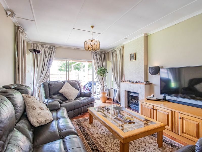 A comfortable living room featuring a fireplace, parquet flooring, and sliding glass doors that provide access to the outdoor area.