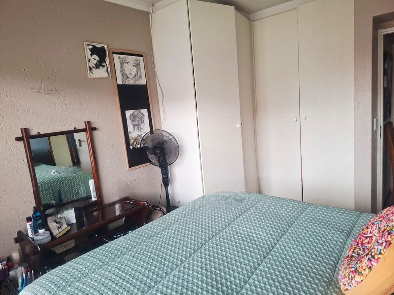 A bedroom featuring built-in cupboards with white doors and textured wall finishes.