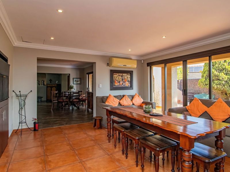 Spacious open-plan living and dining area featuring tiled floors, recessed lighting, and large sliding glass doors providing access to the outdoor patio.