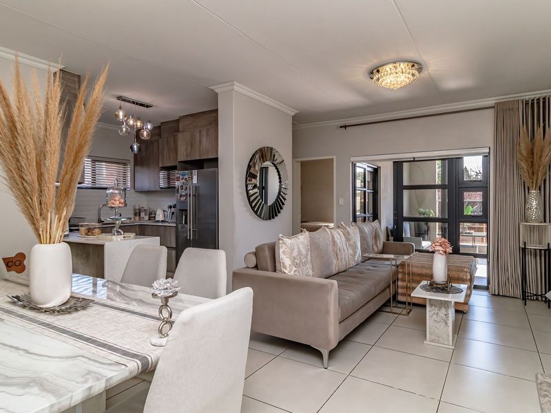 Modern open-plan living and dining area featuring sleek tiled floors, contemporary kitchen cabinetry, and seamless access to the outdoor patio through sliding glass doors.