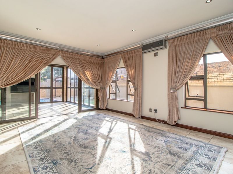 Spacious living area featuring tiled floors, recessed lighting, air conditioning, and large sliding glass doors providing ample natural light and access to the patio.