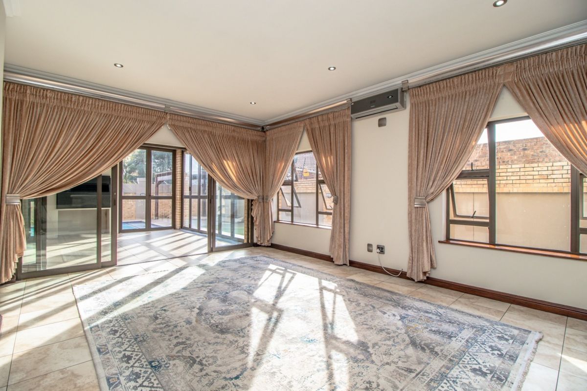 Spacious living area featuring tiled floors, recessed lighting, air conditioning, and large sliding glass doors providing ample natural light and access to the patio.