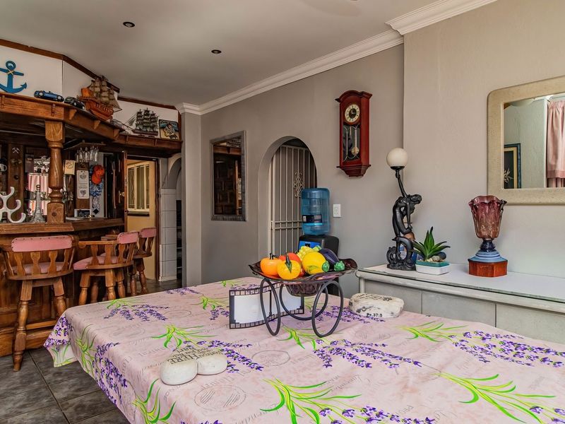 A dedicated bar area featuring a built-in wooden counter, tiled flooring, and an arched entryway, offering a classic entertainment space.