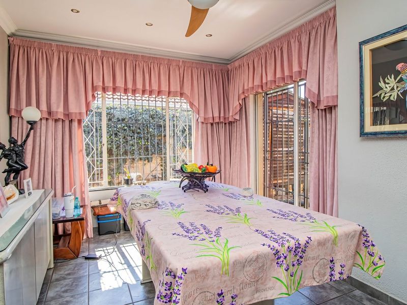Dining room featuring tiled flooring, recessed lighting, a ceiling fan, and large windows with security bars, providing access to the outdoor area.
