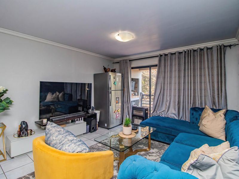 A comfortable living room featuring tiled flooring and a sliding glass door that provides access to the outdoor area.