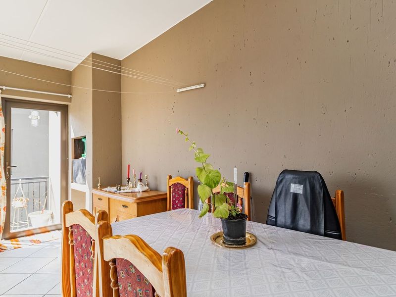 Dining area featuring tiled flooring and a glass sliding door leading to an outdoor space, with a recessed wall niche for storage.