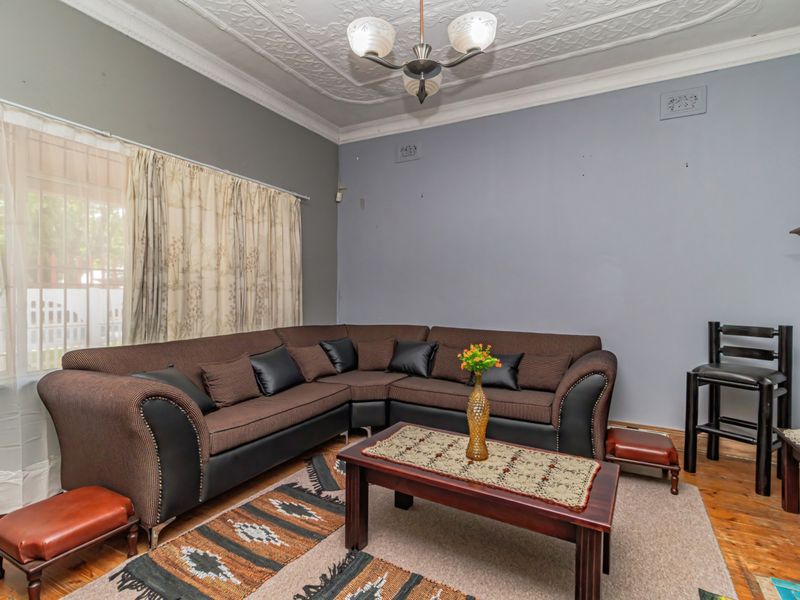 A living room featuring original ornate plaster ceilings, decorative coving, and timber flooring, offering a classic foundation for modern interior updates.