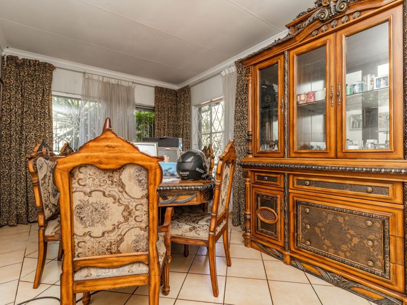 A dining room featuring ceramic floor tiles and windows fitted with security bars, offering a traditional layout.