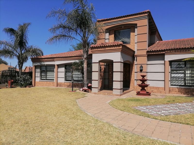 Front elevation of a residential house featuring a tiled roof, covered entrance porch, paved walkway, and security bars on windows.