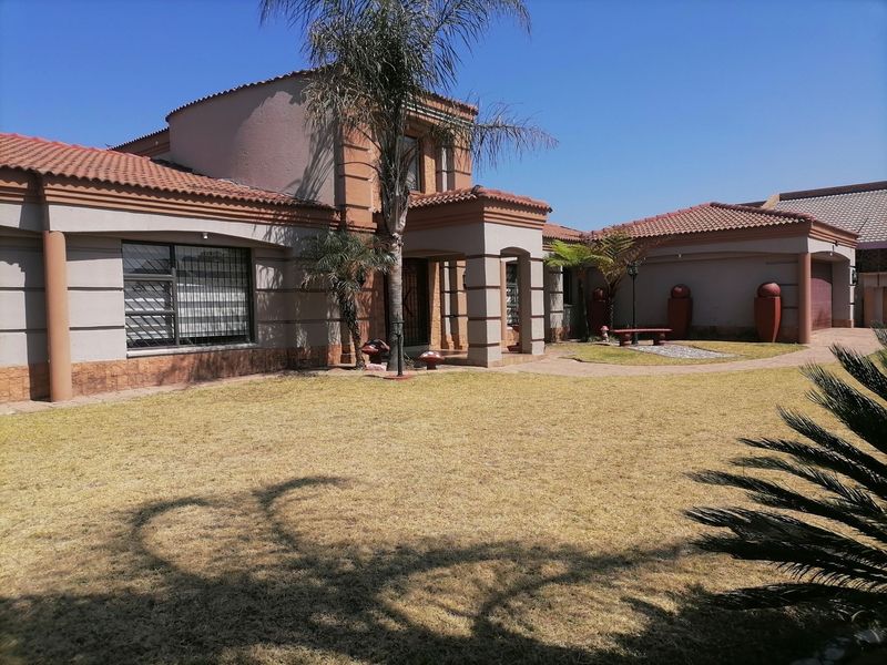 A well-maintained single-story residential property featuring a tiled roof, brick facade, and a paved entrance walkway set within a landscaped front garden.