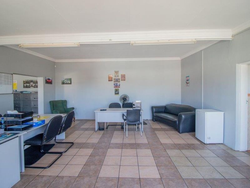 A functional office space featuring tiled flooring, neutral wall finishes, and overhead fluorescent lighting, suitable for a variety of business operations.